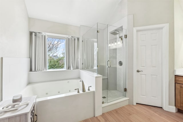 full bathroom featuring a whirlpool tub, a stall shower, wood finished floors, and vanity