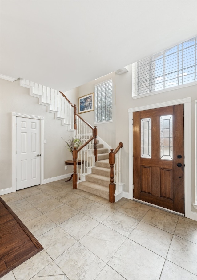 entryway featuring baseboards and stairs