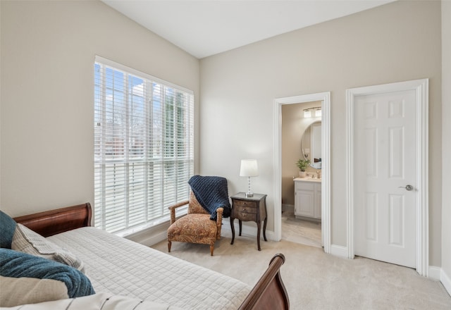 bedroom featuring light carpet, connected bathroom, and baseboards