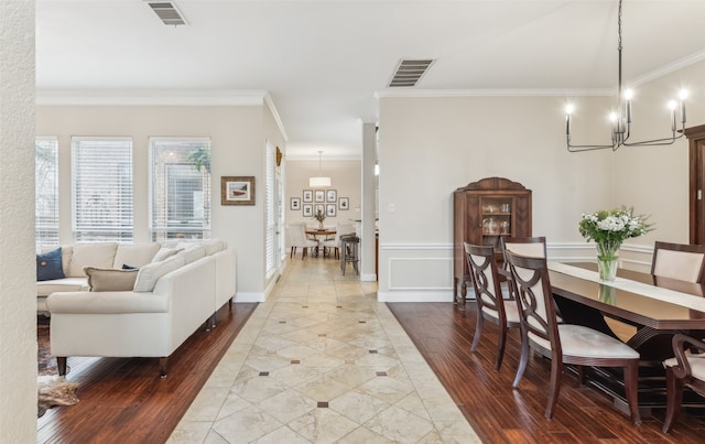 dining space featuring ornamental molding, visible vents, and wood finished floors