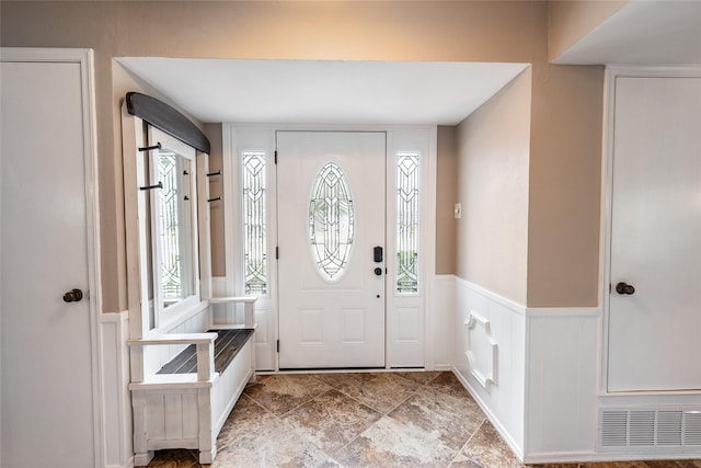 foyer featuring a wealth of natural light, wainscoting, and visible vents