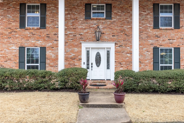 entrance to property featuring brick siding