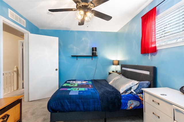 carpeted bedroom featuring a ceiling fan and visible vents