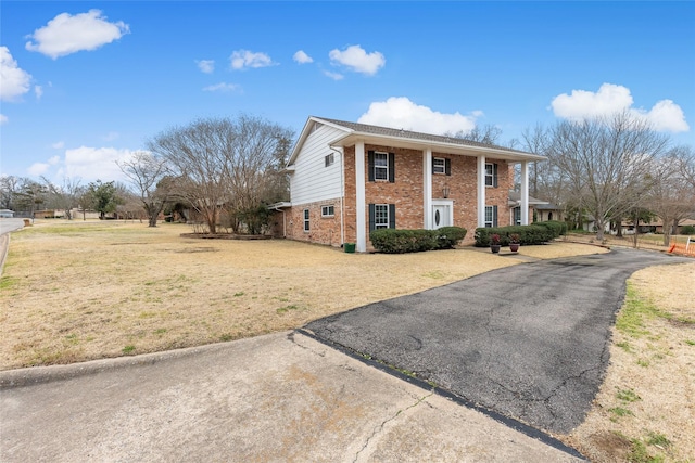 view of front of property featuring a front yard and brick siding