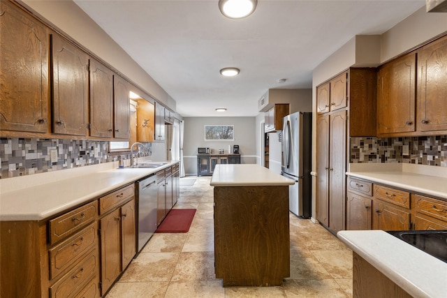 kitchen with tasteful backsplash, a kitchen island, stainless steel appliances, and light countertops