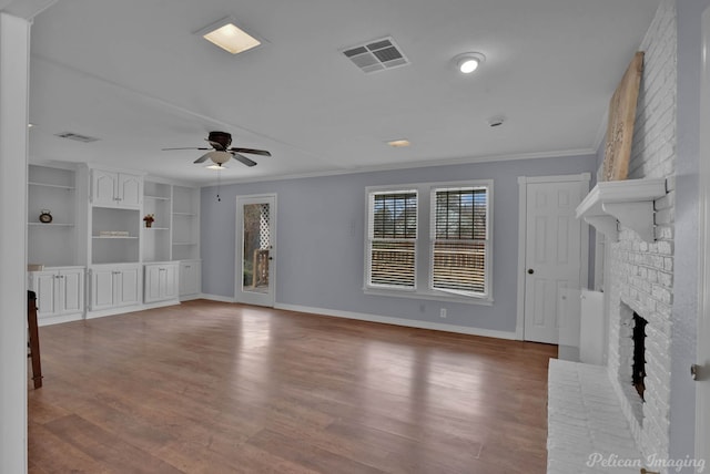 unfurnished living room with visible vents, a ceiling fan, wood finished floors, crown molding, and a fireplace