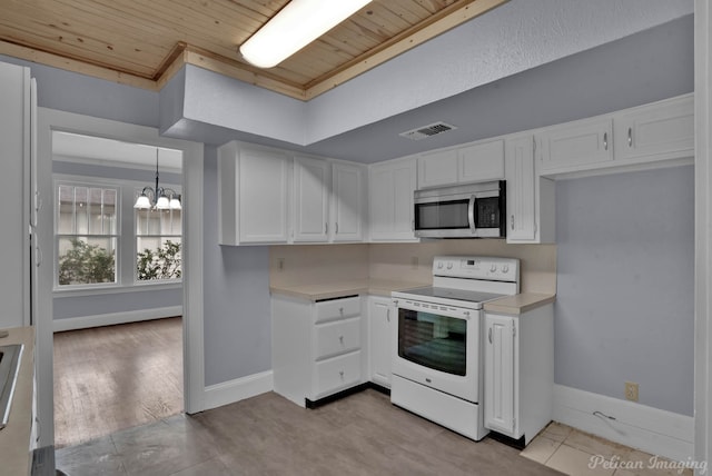 kitchen with visible vents, stainless steel microwave, light countertops, white electric range, and white cabinetry