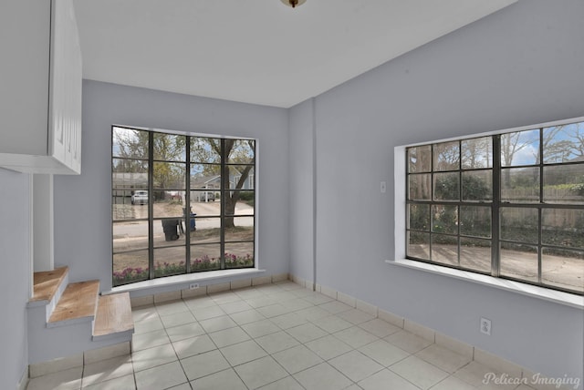 unfurnished room featuring tile patterned flooring and baseboards