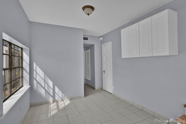 spare room with light tile patterned floors, visible vents, and baseboards