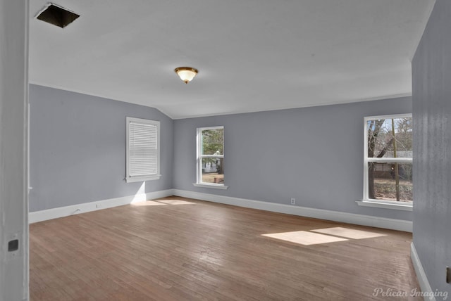 empty room with a healthy amount of sunlight, baseboards, and wood finished floors
