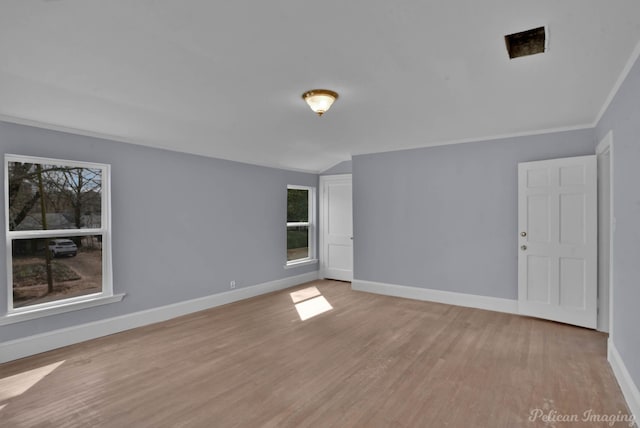 spare room with light wood-type flooring, plenty of natural light, and baseboards