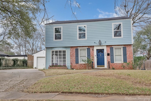 colonial home with driveway, brick siding, a detached garage, fence, and a front yard