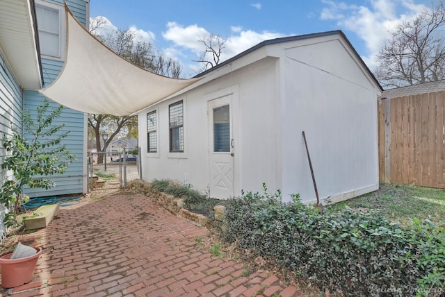 exterior space featuring fence, a patio, and an outdoor structure