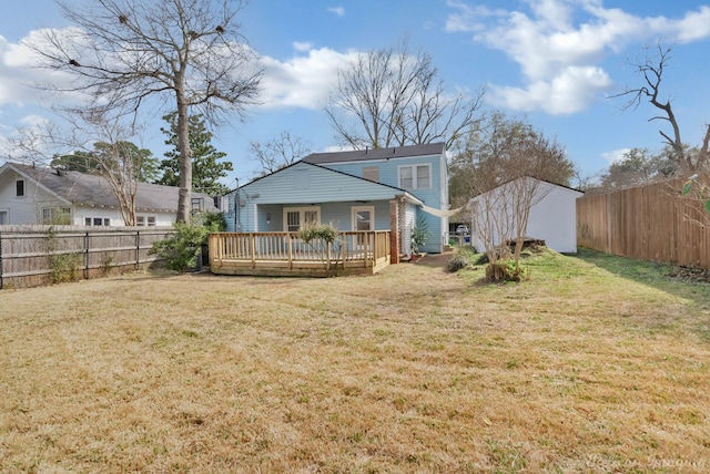 back of house featuring a fenced backyard, a lawn, and a wooden deck