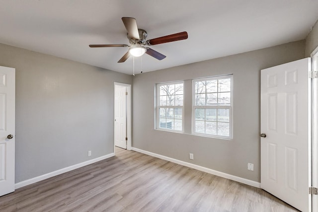 unfurnished bedroom featuring a ceiling fan, light wood-style flooring, and baseboards