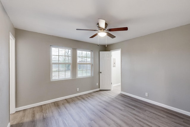 unfurnished room featuring a ceiling fan, baseboards, and wood finished floors