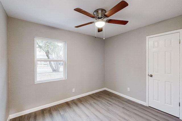 empty room with a ceiling fan, baseboards, and wood finished floors