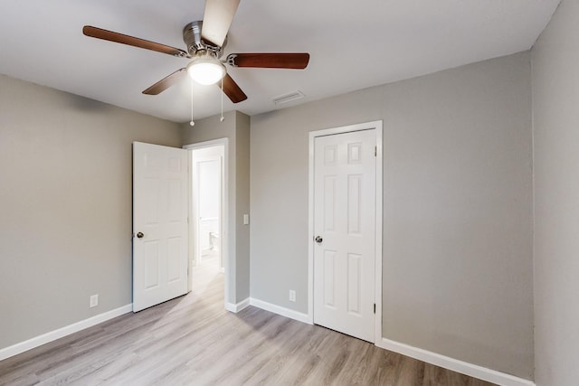 unfurnished bedroom with light wood-style flooring, a ceiling fan, visible vents, and baseboards