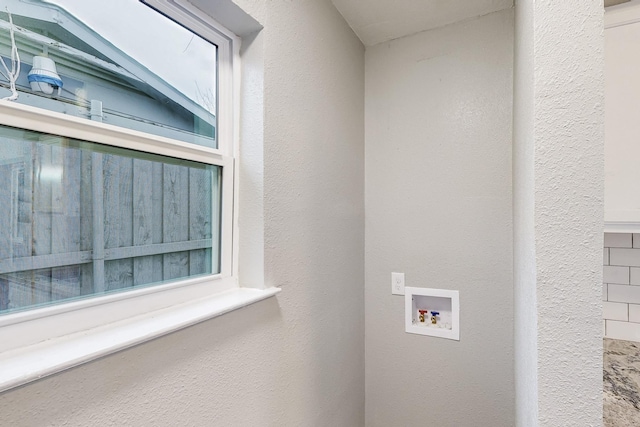 laundry room with hookup for a washing machine, laundry area, and a textured wall