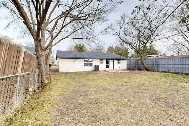 back of property featuring a fenced backyard, cooling unit, and a lawn