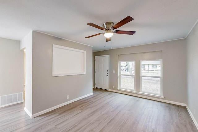 unfurnished room featuring ceiling fan, visible vents, baseboards, light wood-style floors, and ornamental molding