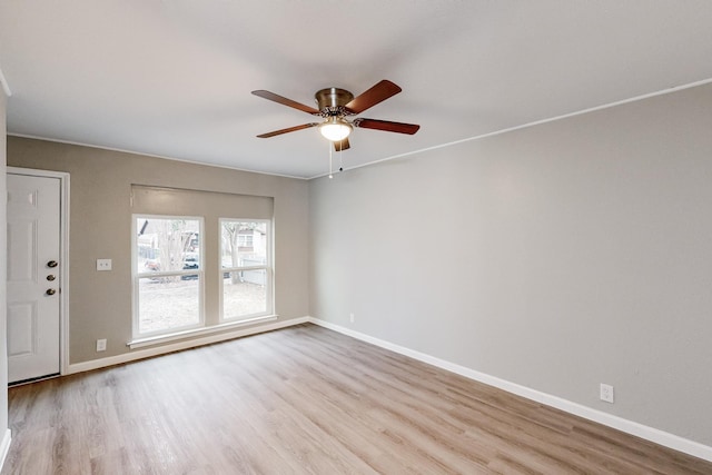 empty room with a ceiling fan, baseboards, and wood finished floors