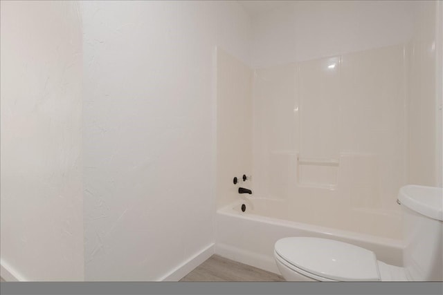 full bathroom featuring baseboards, shower / bathing tub combination, toilet, and wood finished floors