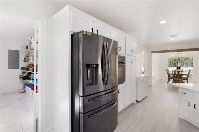 kitchen with visible vents, white cabinets, black oven, electric panel, and stainless steel fridge with ice dispenser