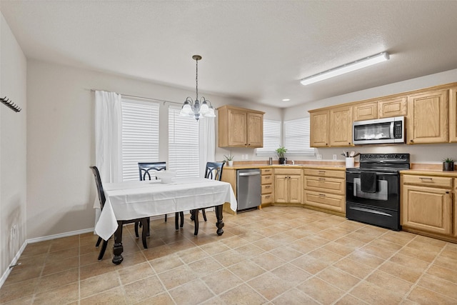 kitchen featuring light countertops, appliances with stainless steel finishes, hanging light fixtures, and light brown cabinets