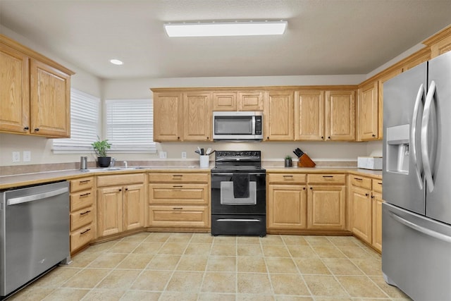 kitchen featuring stainless steel appliances, light countertops, light tile patterned floors, and light brown cabinetry