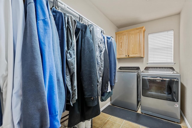 laundry room featuring tile patterned flooring, washing machine and clothes dryer, and cabinet space