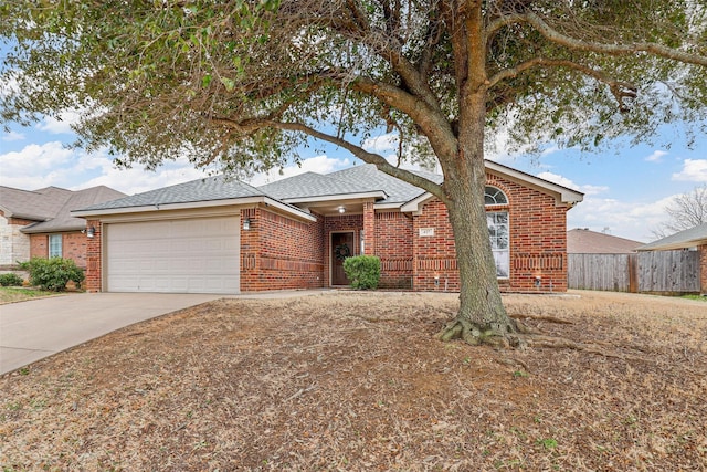 single story home featuring brick siding, roof with shingles, concrete driveway, fence, and a garage