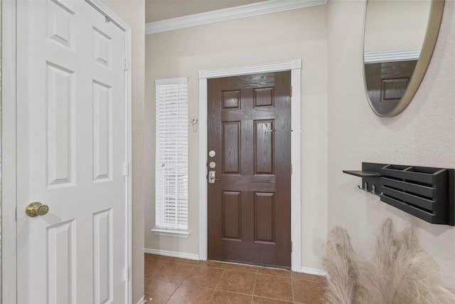 tiled entryway featuring baseboards and crown molding