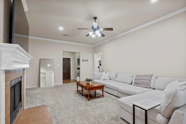 living area featuring light carpet, a tile fireplace, visible vents, and crown molding