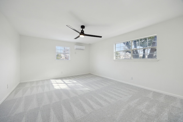 empty room with carpet floors, a wall mounted air conditioner, and baseboards