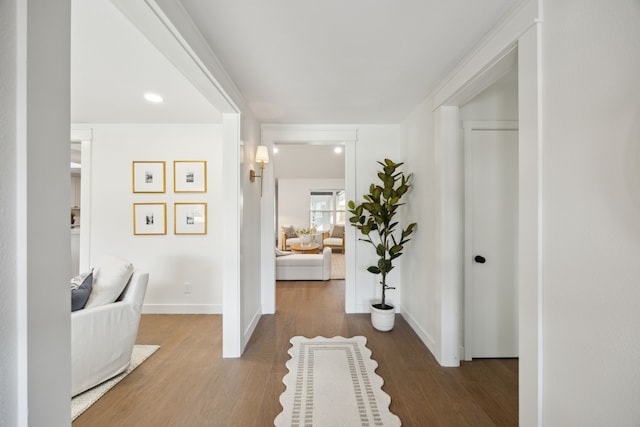 corridor with baseboards and wood finished floors