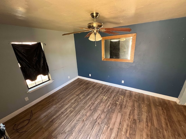 spare room featuring ceiling fan, baseboards, and wood finished floors