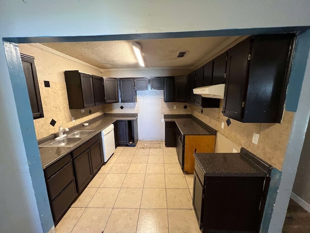 kitchen with visible vents, dishwasher, a sink, under cabinet range hood, and backsplash