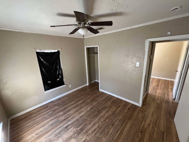 unfurnished bedroom featuring a closet, crown molding, baseboards, and wood finished floors