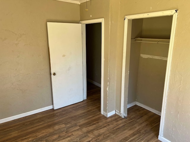 unfurnished bedroom featuring a closet, wood finished floors, and baseboards