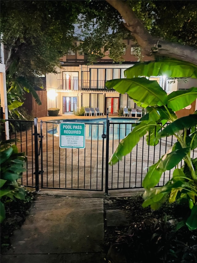 exterior space featuring a community pool and fence