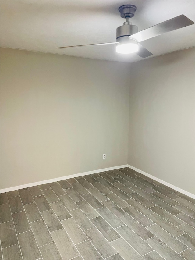 spare room featuring a ceiling fan, baseboards, and wood finish floors