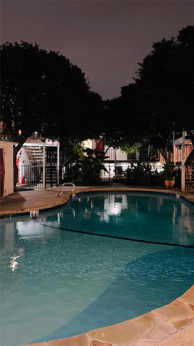 pool with a patio and fence