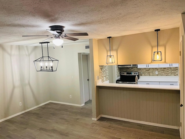 kitchen featuring dark wood-style floors, stainless steel electric stove, backsplash, and light countertops