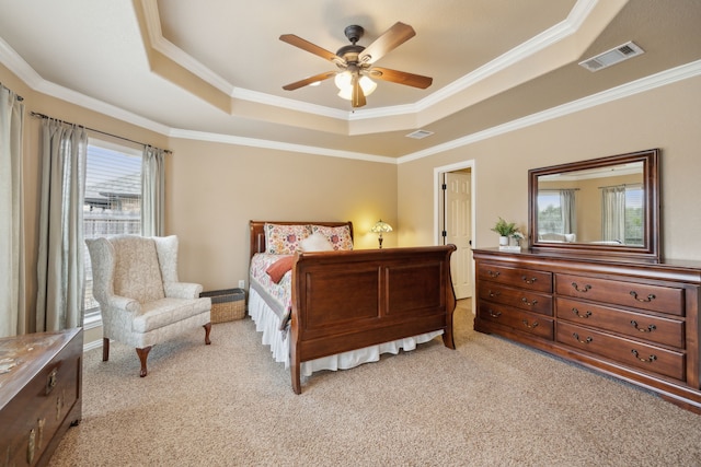 bedroom featuring a raised ceiling, ornamental molding, visible vents, and light carpet