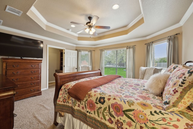 bedroom featuring visible vents, carpet, ornamental molding, a textured ceiling, and a raised ceiling