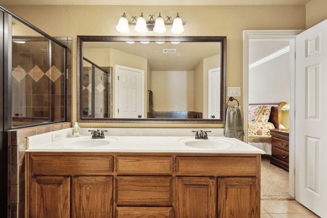 ensuite bathroom featuring tile patterned flooring, visible vents, a stall shower, and a sink