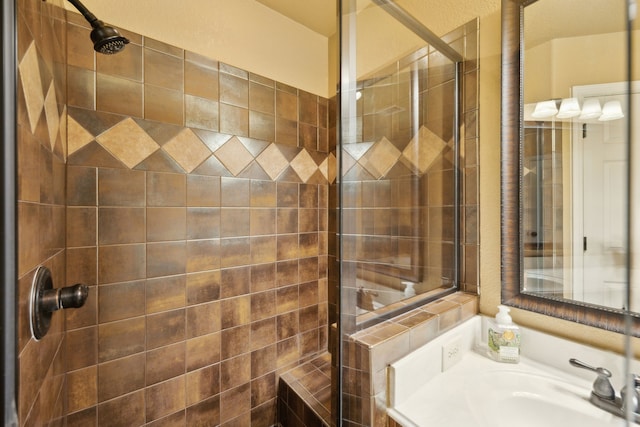 bathroom with a tile shower and a sink