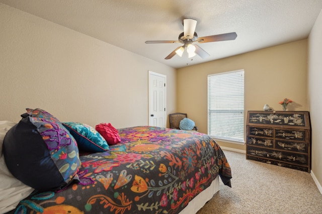 bedroom with carpet flooring, a ceiling fan, baseboards, and a textured ceiling