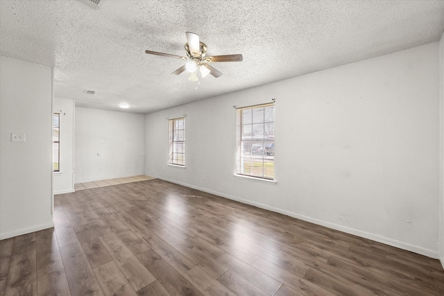 spare room with a ceiling fan, a textured ceiling, baseboards, and wood finished floors